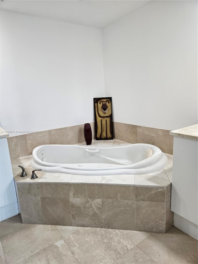 full bathroom featuring a tub with jets and vanity