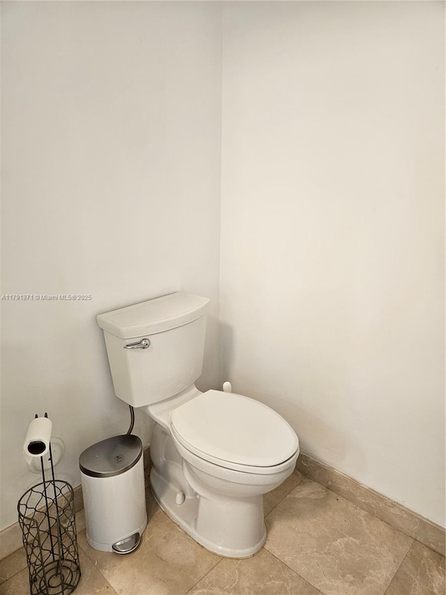 bathroom featuring baseboards and toilet