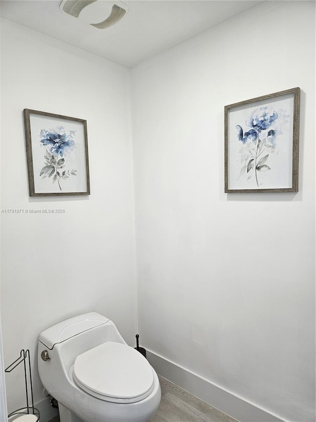 bathroom featuring toilet and baseboards