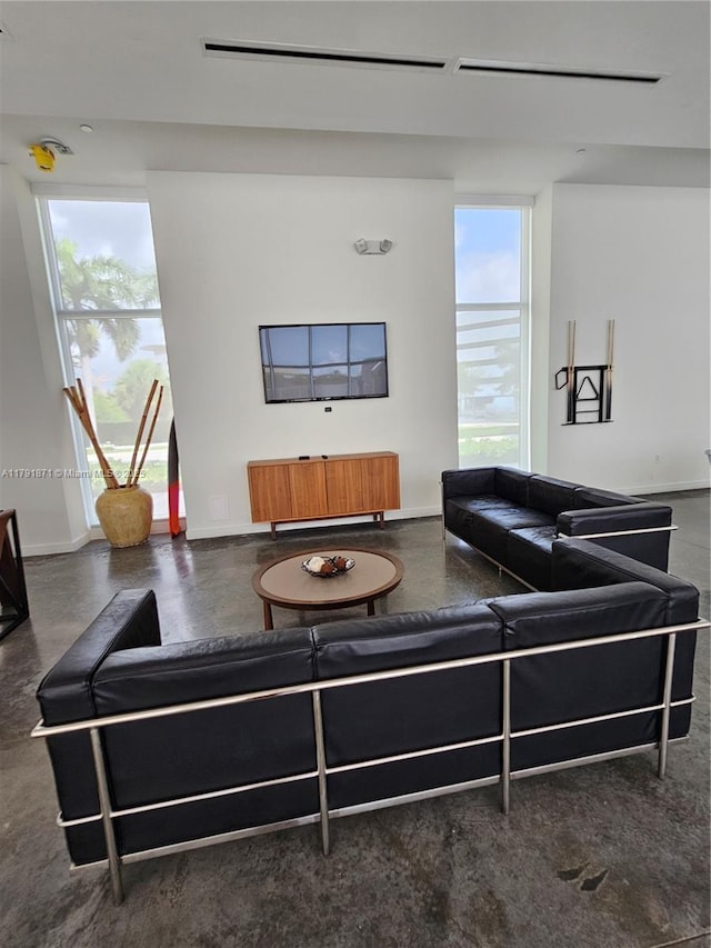 15051 Royal Oaks Ln Unit 2202, North Miami, FL 33181 - living area with healthy amount of natural light, baseboards, and finished concrete floors