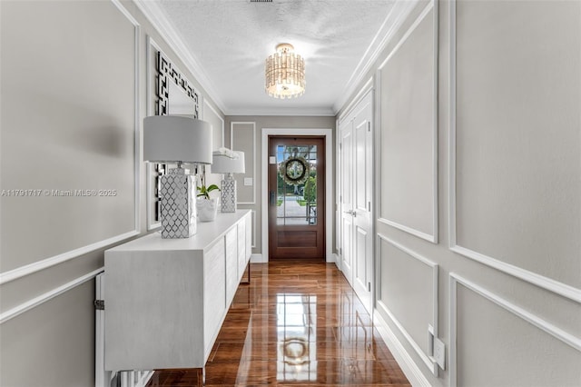 doorway to outside featuring ornamental molding and an inviting chandelier