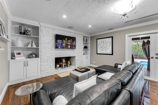 living room featuring a textured ceiling, wood finished floors, built in features, and baseboards