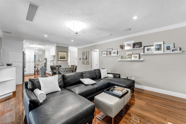 living area featuring wood finished floors, visible vents, crown molding, and baseboards