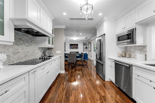 kitchen featuring dark wood finished floors, appliances with stainless steel finishes, white cabinetry, a textured ceiling, and open floor plan