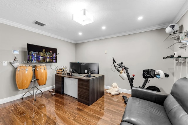 home office with visible vents, wood finished floors, ornamental molding, and baseboards