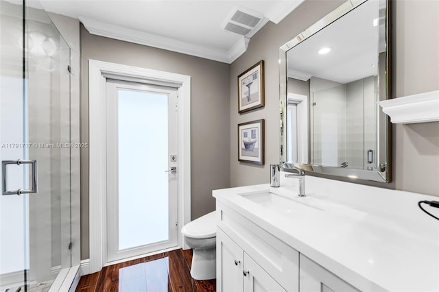 full bathroom with visible vents, a stall shower, toilet, ornamental molding, and wood finished floors