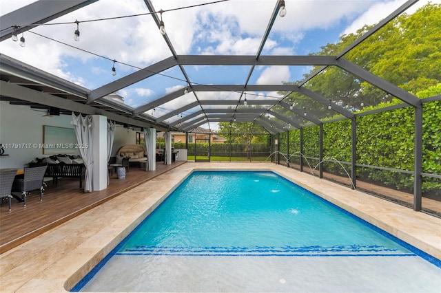 outdoor pool featuring a patio, a wooden deck, and a lanai