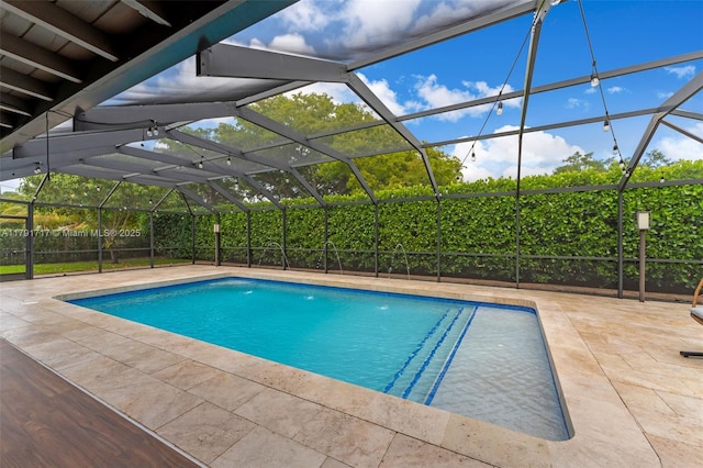 outdoor pool featuring a patio, fence, and a lanai