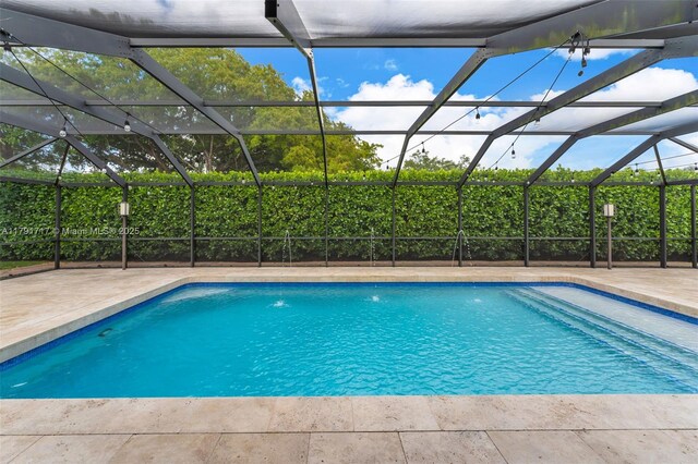 outdoor pool featuring a lanai and a patio area
