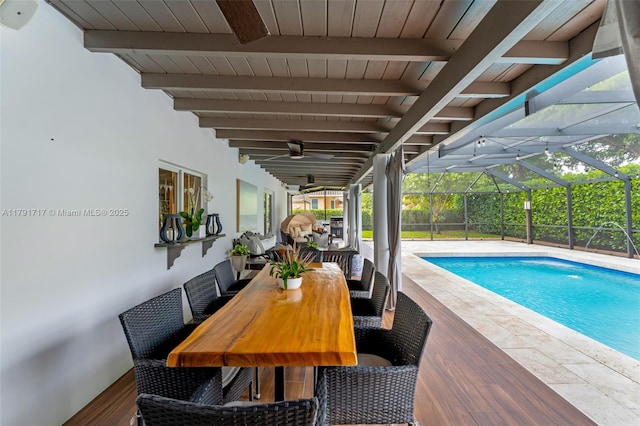 outdoor pool featuring a patio, glass enclosure, ceiling fan, and outdoor dining area