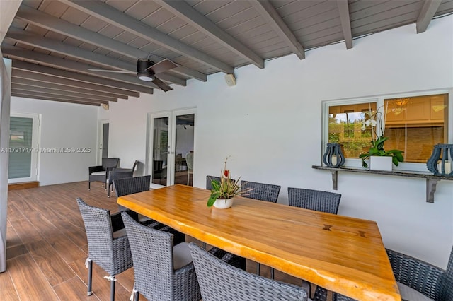 dining space featuring beamed ceiling, ceiling fan, and wood finished floors