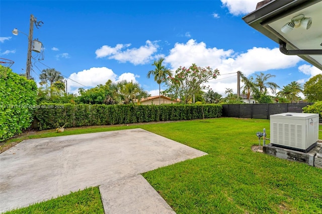 view of yard featuring a fenced backyard, central air condition unit, and a patio area