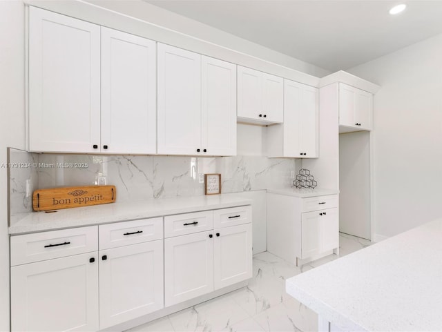 923 Winters St E, Lehigh Acres, FL 33974 - kitchen with recessed lighting, light countertops, marble finish floor, backsplash, and white cabinetry