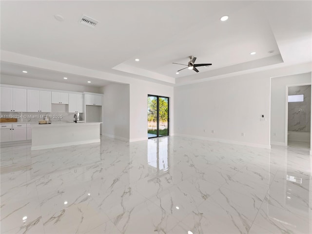 923 Winters St E, Lehigh Acres, FL 33974 - unfurnished living room featuring a raised ceiling, recessed lighting, visible vents, and baseboards