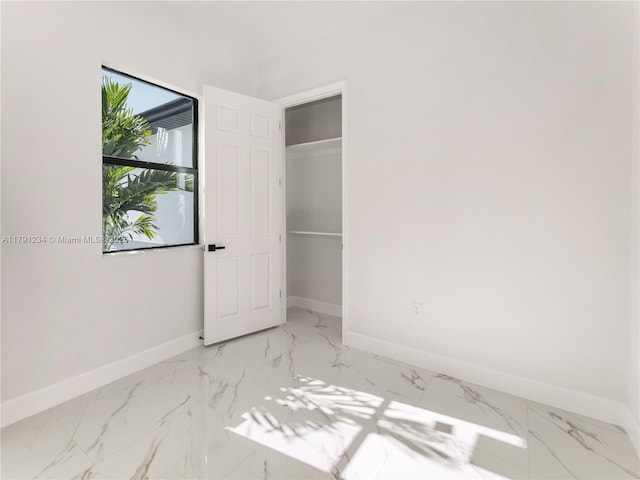 923 Winters St E, Lehigh Acres, FL 33974 - unfurnished bedroom with a closet, marble finish floor, and baseboards