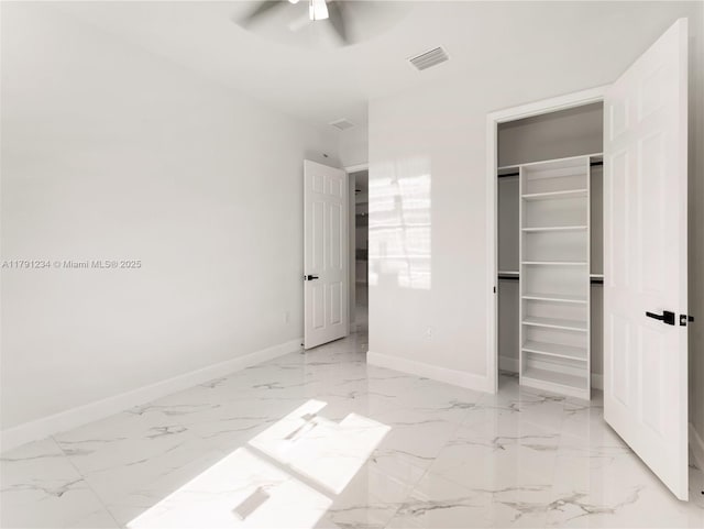 923 Winters St E, Lehigh Acres, FL 33974 - unfurnished bedroom featuring a closet, marble finish floor, a walk in closet, visible vents, and baseboards