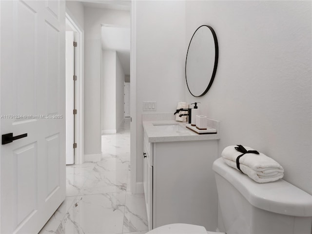 923 Winters St E, Lehigh Acres, FL 33974 - bathroom with baseboards, toilet, vanity, and marble finish floor
