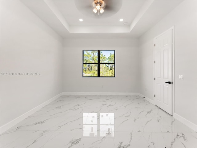 923 Winters St E, Lehigh Acres, FL 33974 - spare room featuring recessed lighting, marble finish floor, baseboards, a ceiling fan, and a tray ceiling