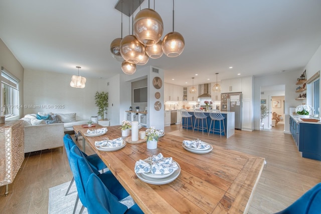 dining area with visible vents, recessed lighting, light wood finished floors, and a notable chandelier