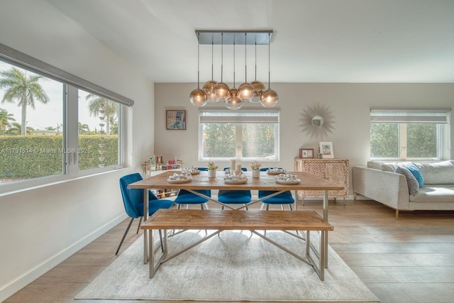 dining space featuring a notable chandelier, a wealth of natural light, and light wood-style floors