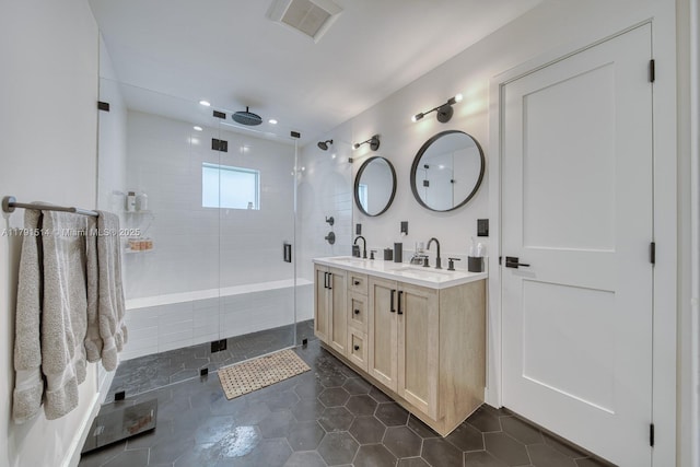 full bathroom featuring a sink, a shower stall, double vanity, and visible vents