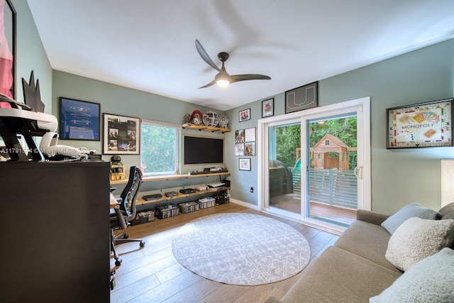 office space featuring a healthy amount of sunlight, baseboards, a ceiling fan, and wood finished floors