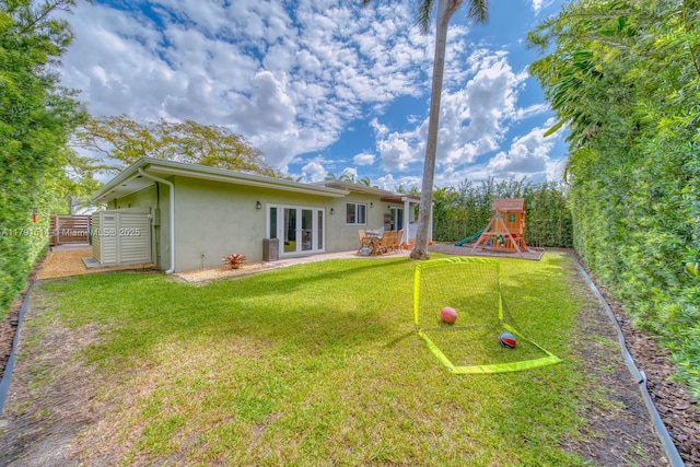 view of yard featuring french doors, a patio area, and a playground