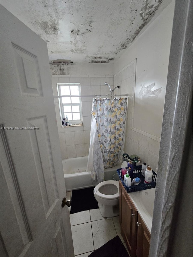 full bathroom with shower / tub combo with curtain, toilet, tile walls, vanity, and tile patterned flooring
