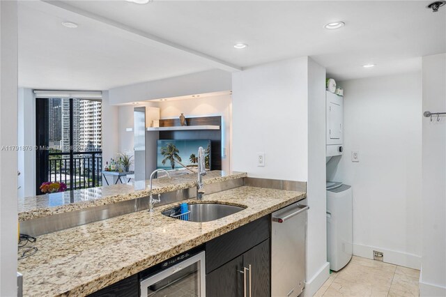 540 Brickell Key Dr Unit 1411, Miami, FL 33131 - kitchen with a sink, estacked washer and dryer, dishwasher, baseboards, and light stone counters