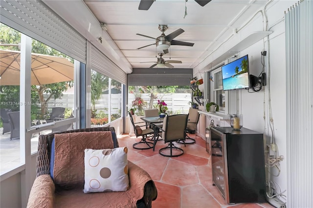 sunroom featuring outdoor dining area and a ceiling fan