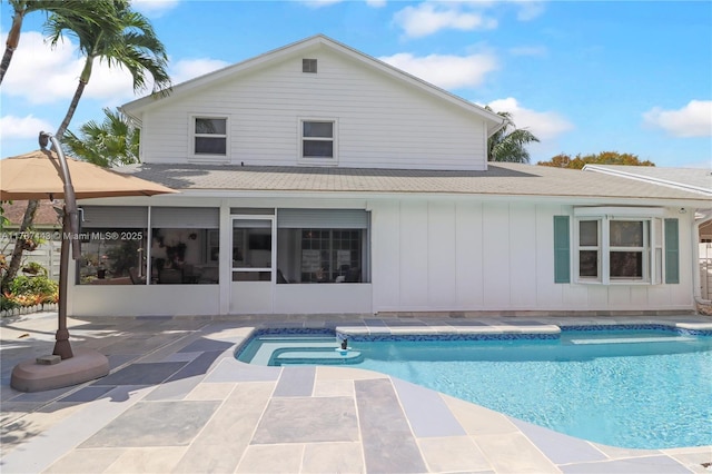 outdoor pool featuring a sunroom and a patio area
