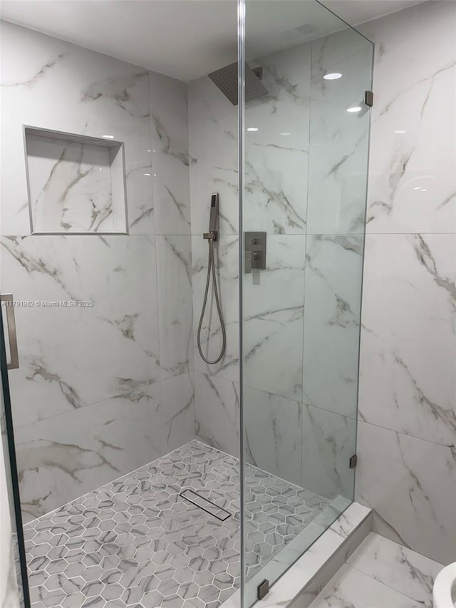 full bathroom featuring a marble finish shower