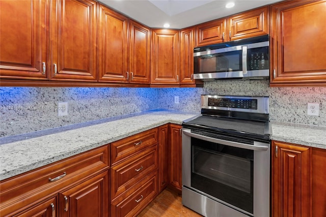 300 SW 130th Ter Unit 203B, Pembroke Pines, FL 33027 - kitchen with stainless steel appliances, light stone counters, decorative backsplash, recessed lighting, and wood finished floors