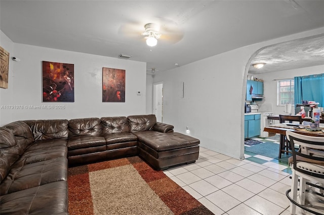 living area with ceiling fan, baseboards, visible vents, and arched walkways