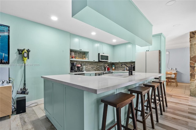 3030 SW 77th Ct, Miami, FL 33155 - kitchen with freestanding refrigerator, tasteful backsplash, light wood-style flooring, and stainless steel microwave