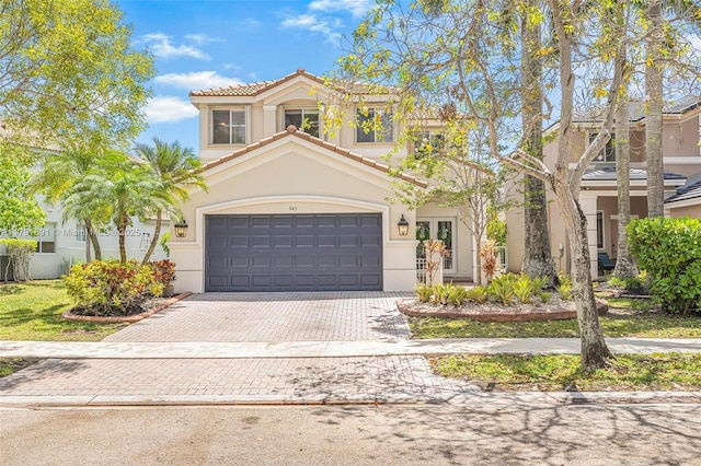 943 Golden Cane Dr, Weston, FL 33327 - mediterranean / spanish-style home featuring decorative driveway, stucco siding, a tiled roof, and a garage