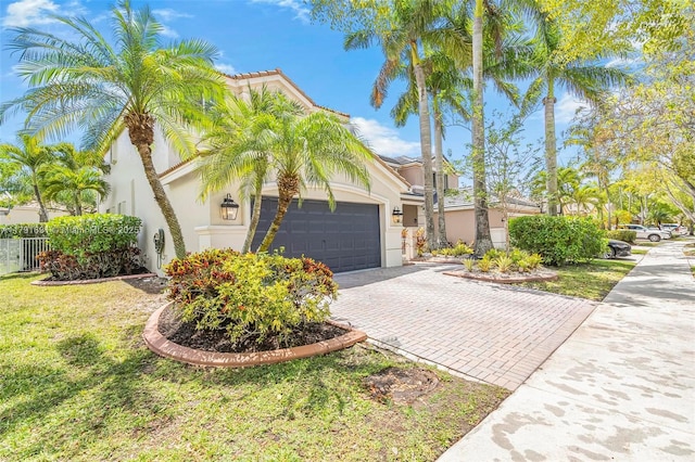 943 Golden Cane Dr, Weston, FL 33327 - view of front of house with stucco siding, fence, decorative driveway, a front lawn, and an attached garage
