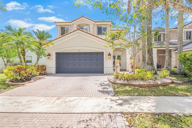 943 Golden Cane Dr, Weston, FL 33327 - mediterranean / spanish-style house with stucco siding, decorative driveway, an attached garage, and a tile roof