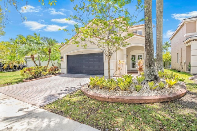 943 Golden Cane Dr, Weston, FL 33327 - mediterranean / spanish-style house featuring stucco siding, decorative driveway, and an attached garage
