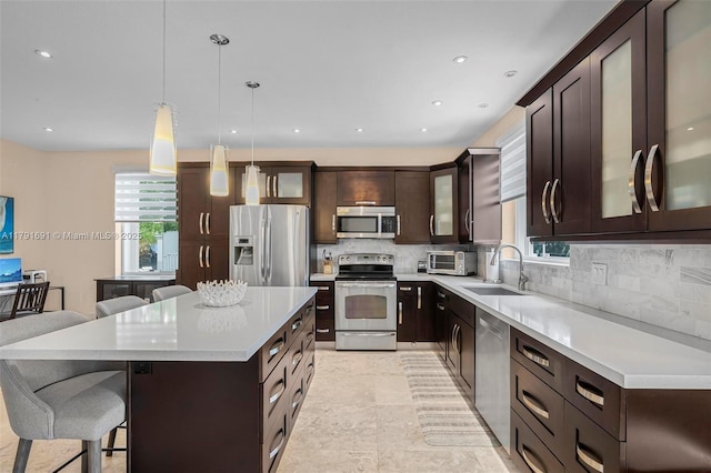 943 Golden Cane Dr, Weston, FL 33327 - kitchen with a sink, stainless steel appliances, a breakfast bar, backsplash, and dark brown cabinets