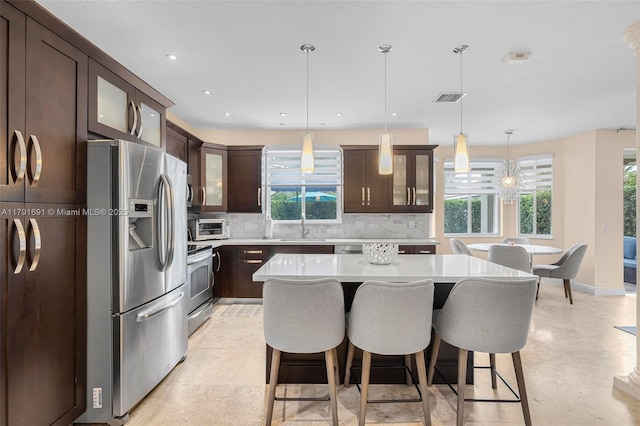 943 Golden Cane Dr, Weston, FL 33327 - kitchen featuring tasteful backsplash, a wealth of natural light, appliances with stainless steel finishes, dark brown cabinets, and visible vents