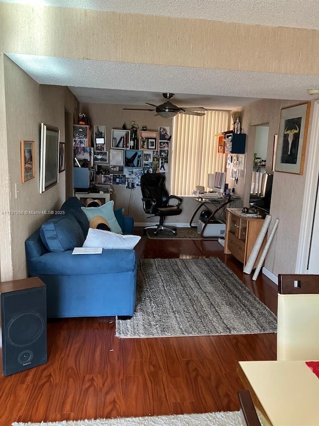 living area featuring a textured ceiling, wood finished floors, and a ceiling fan