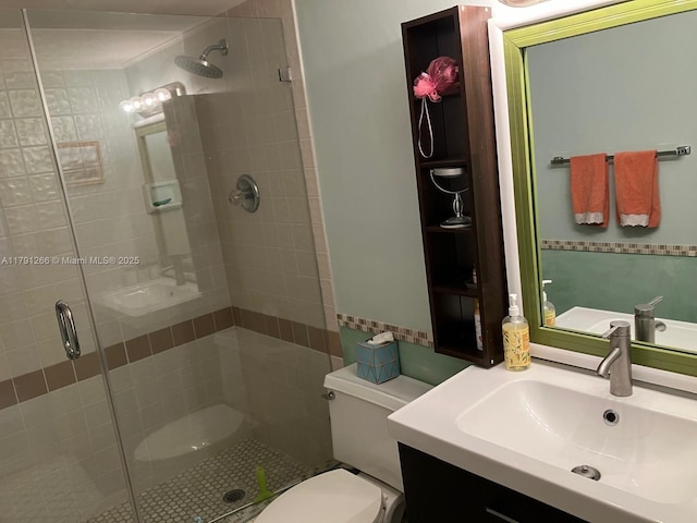 bathroom with toilet, a stall shower, and vanity
