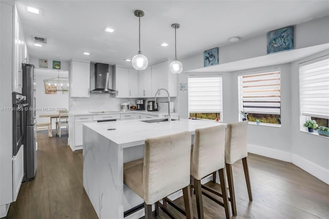 8323 NW 196th Ter, Hialeah, FL 33015 - kitchen featuring wall chimney range hood, white cabinetry, a sink, visible vents, and baseboards