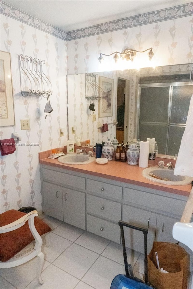 full bathroom with tile patterned floors, a shower stall, double vanity, and a sink