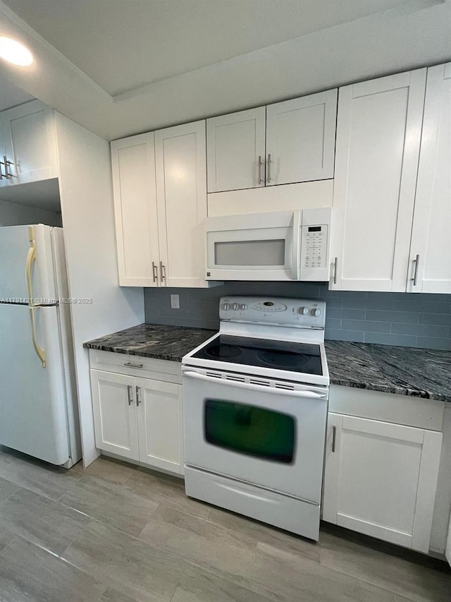 9851 Sandalfoot Blvd Unit 208, Boca Raton, FL 33428 - kitchen featuring white appliances, white cabinets, decorative backsplash, and dark stone counters