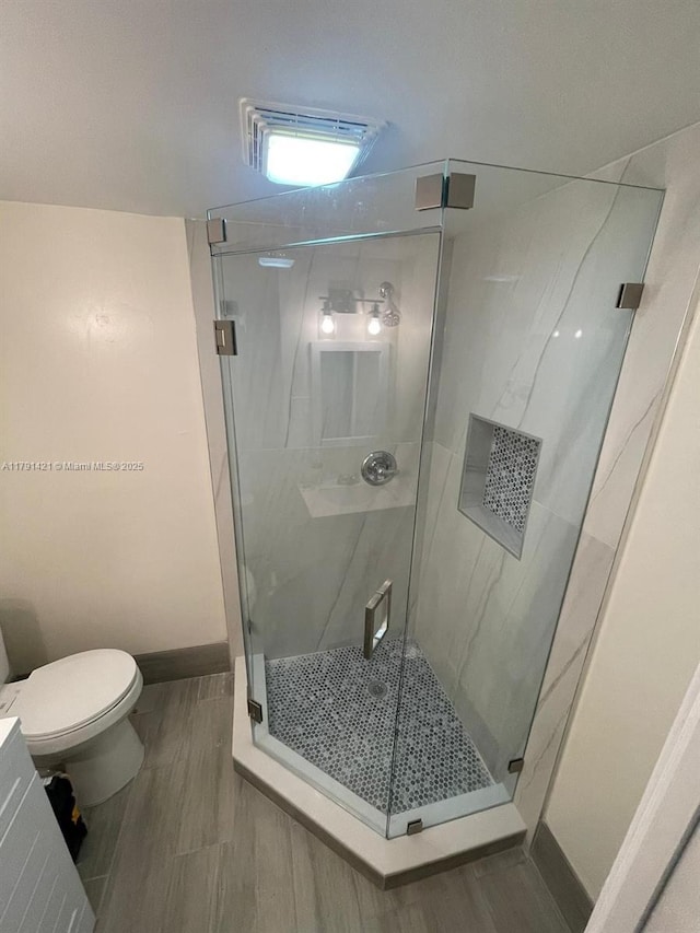9851 Sandalfoot Blvd Unit 208, Boca Raton, FL 33428 - full bathroom with a shower stall, toilet, baseboards, and wood finished floors