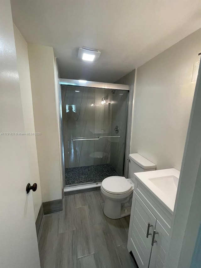 9851 Sandalfoot Blvd Unit 208, Boca Raton, FL 33428 - bathroom with toilet, vanity, a stall shower, and wood finished floors