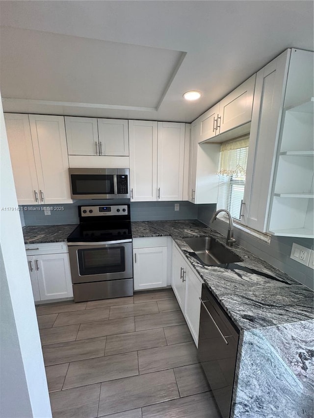 9851 Sandalfoot Blvd Unit 208, Boca Raton, FL 33428 - kitchen featuring appliances with stainless steel finishes, a sink, white cabinets, dark stone counters, and recessed lighting