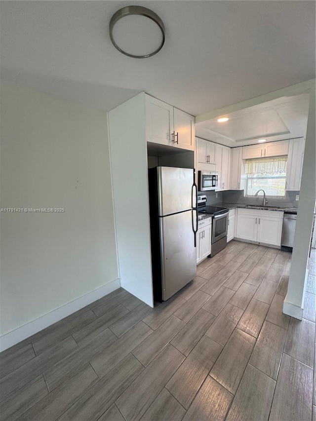 9851 Sandalfoot Blvd Unit 208, Boca Raton, FL 33428 - kitchen with stainless steel appliances, wood tiled floors, white cabinets, and a sink